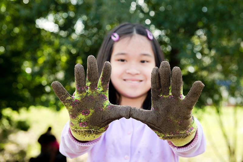 Youth with dirty gardening gloves